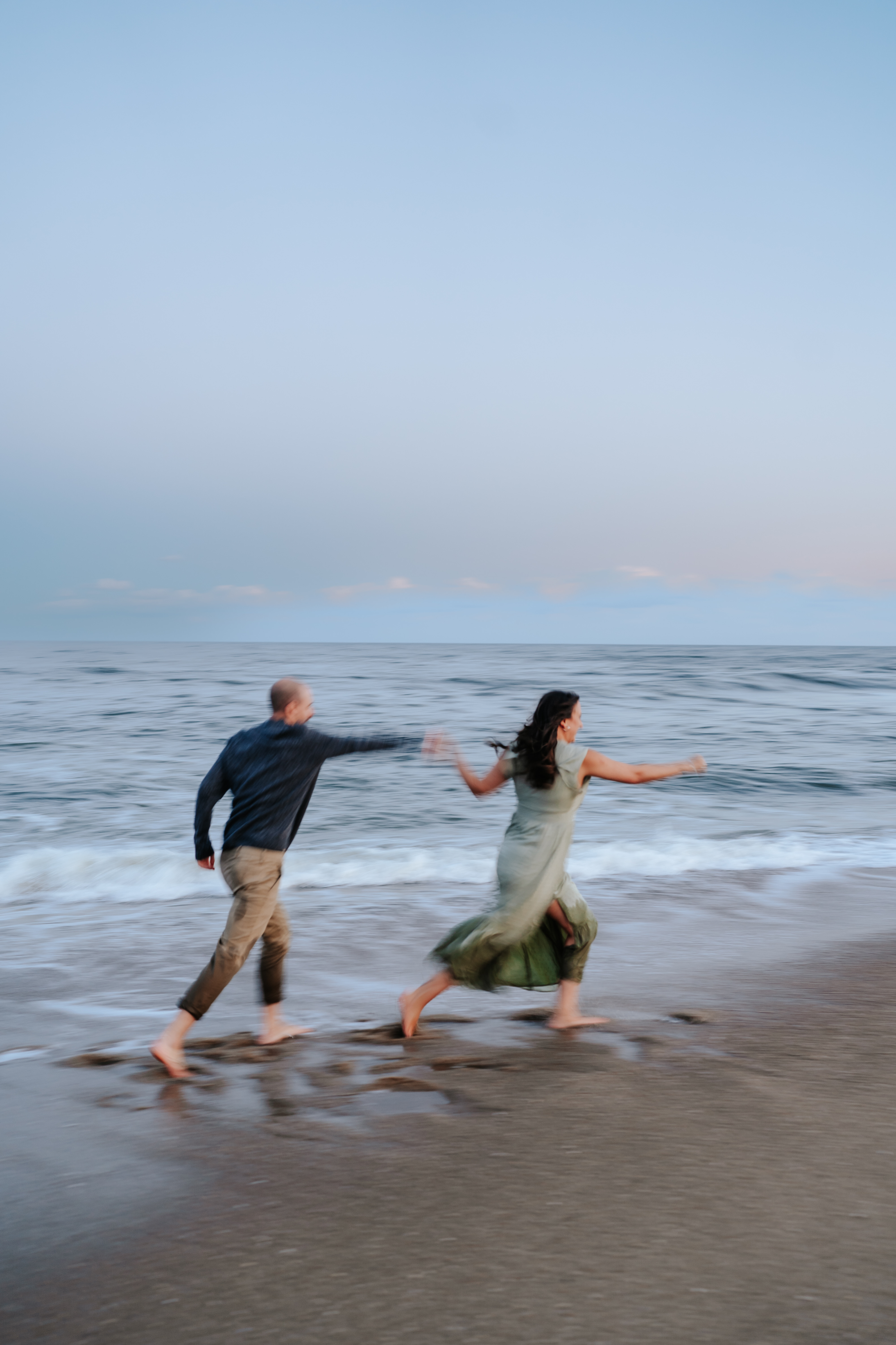 A couple at Asbury Park Beach during their engagement session with Maryland Wedding Photographer capturing the serene ocean backdrop.