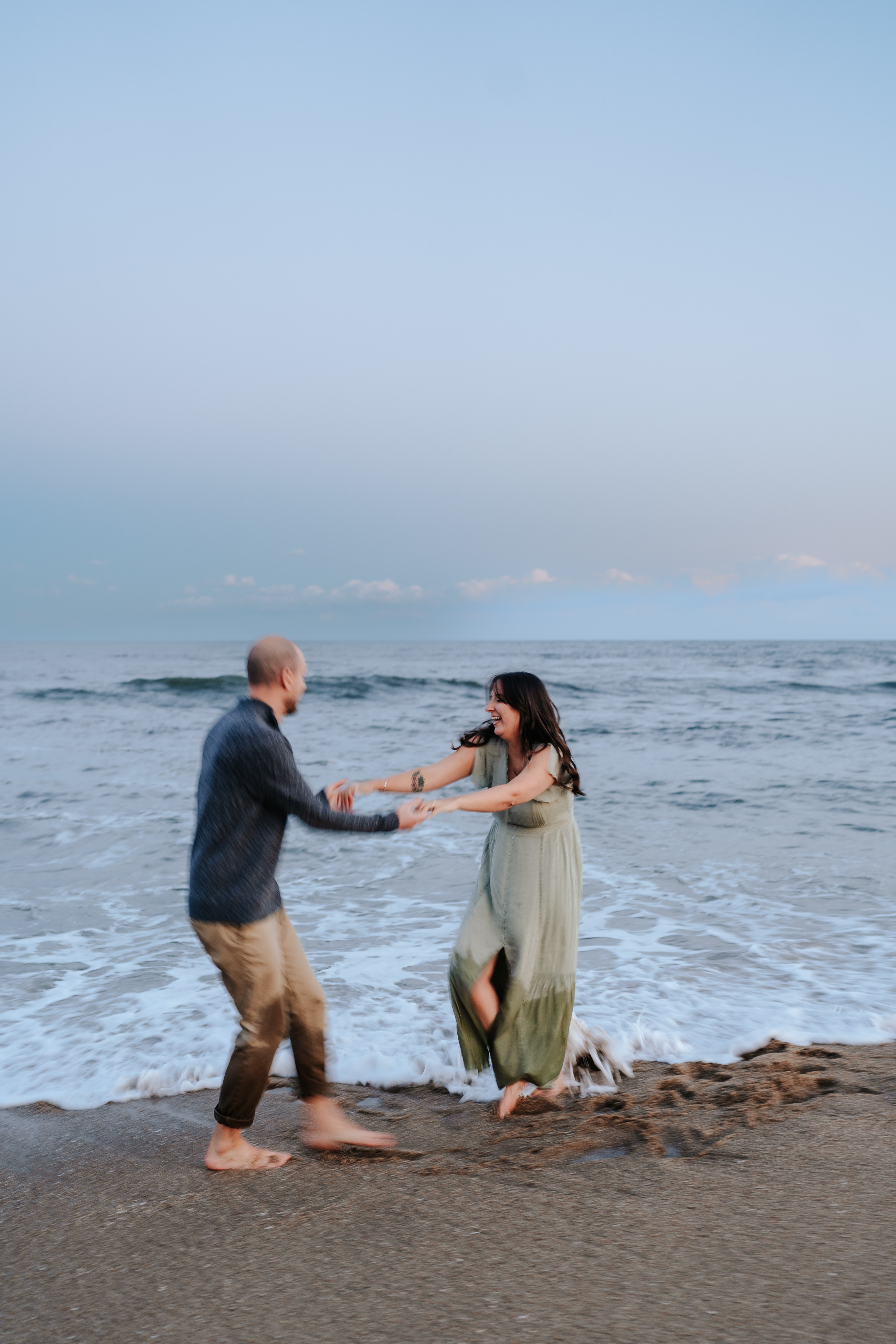 A couple at Asbury Park Beach during their engagement session with Maryland Wedding Photographer capturing the serene ocean backdrop.