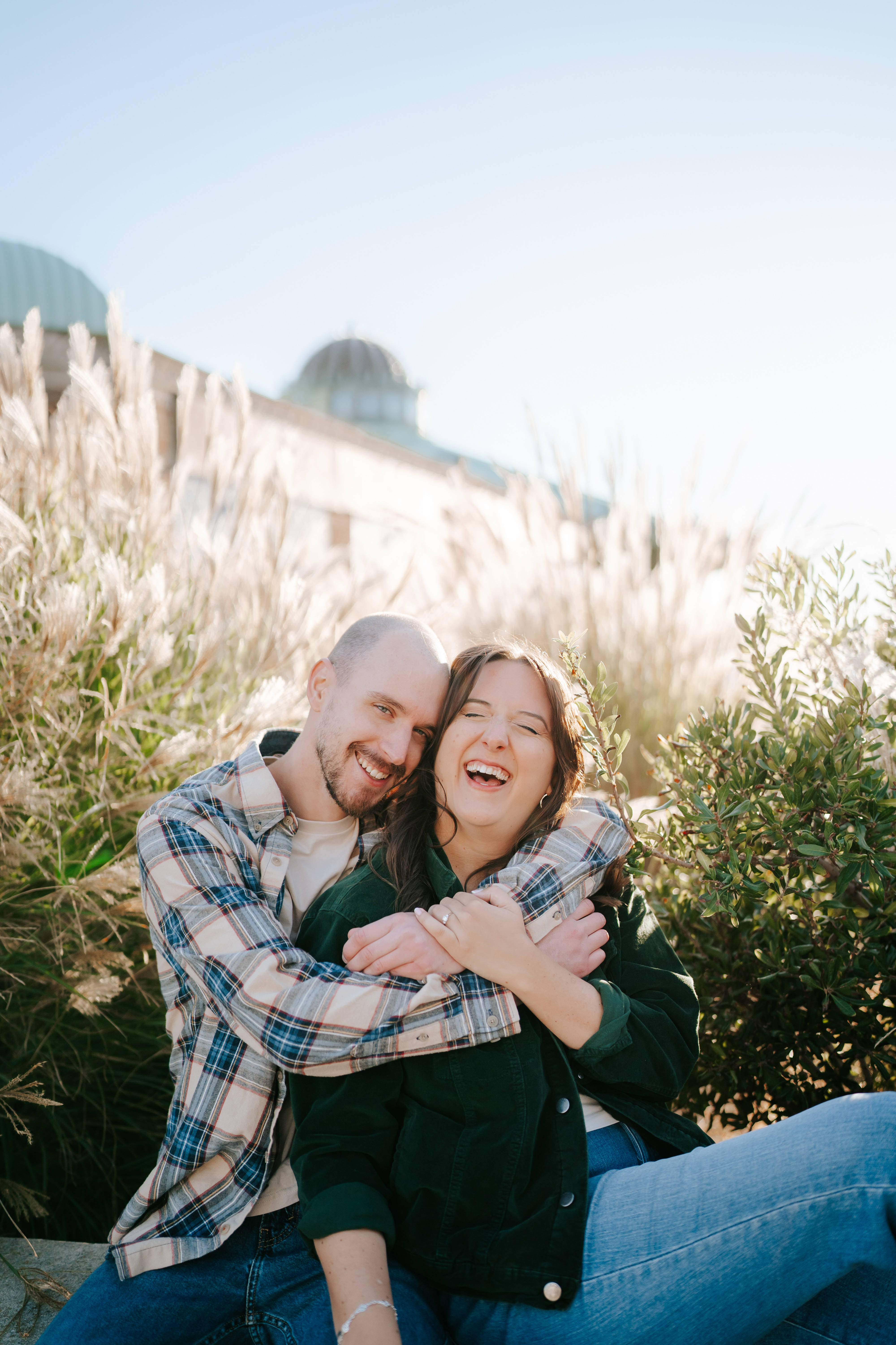 Joyful couple sharing a candid moment during their engagement photo shoot at Asbury Park Boardwalk, captured by Brenna Marie Photography, Maryland's true-to-color and candid storyteller for laid-back couples