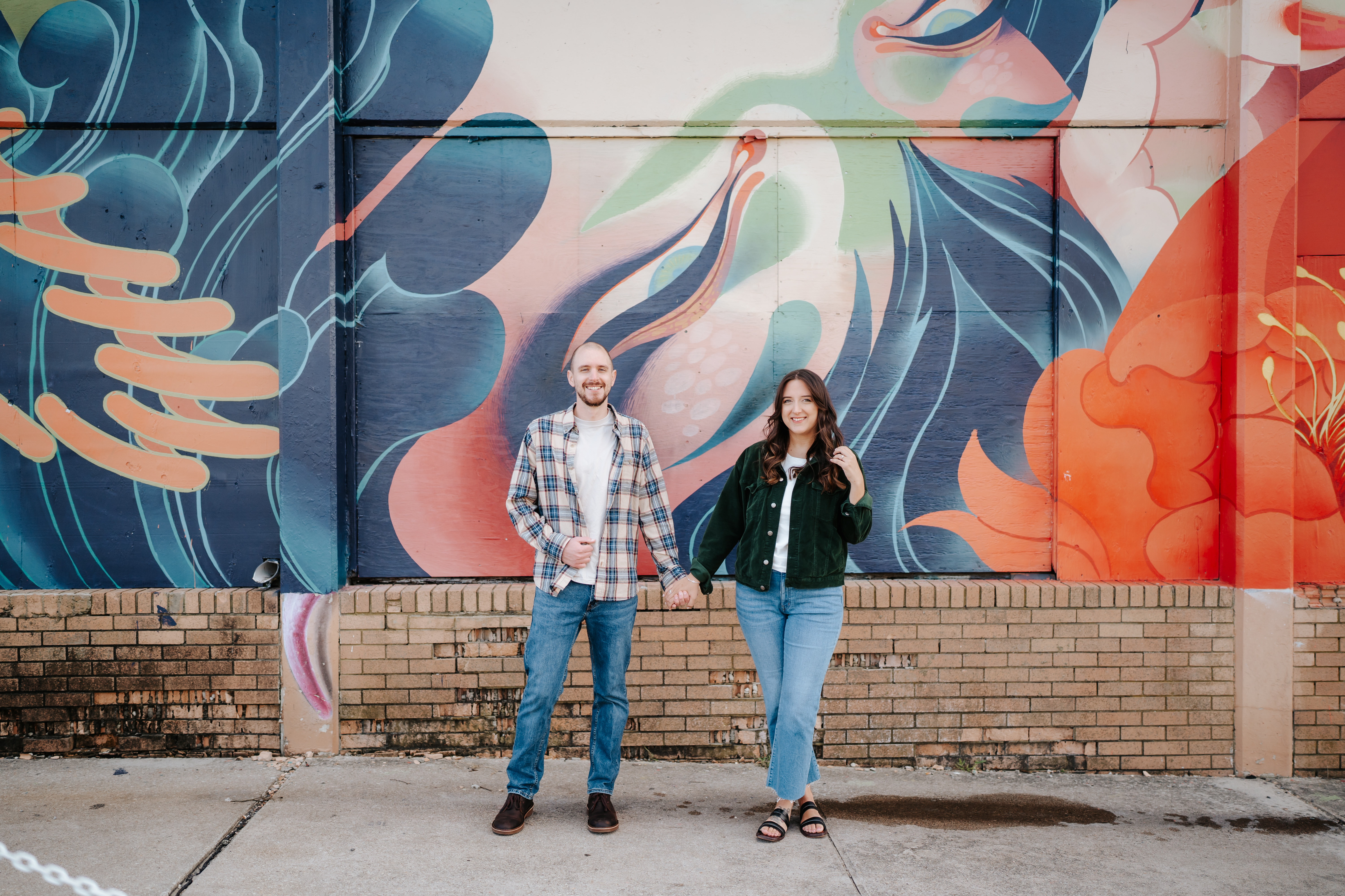 A couple at Asbury Park Beach during their engagement session with Maryland Wedding Photographer capturing the artistic mural backdrops