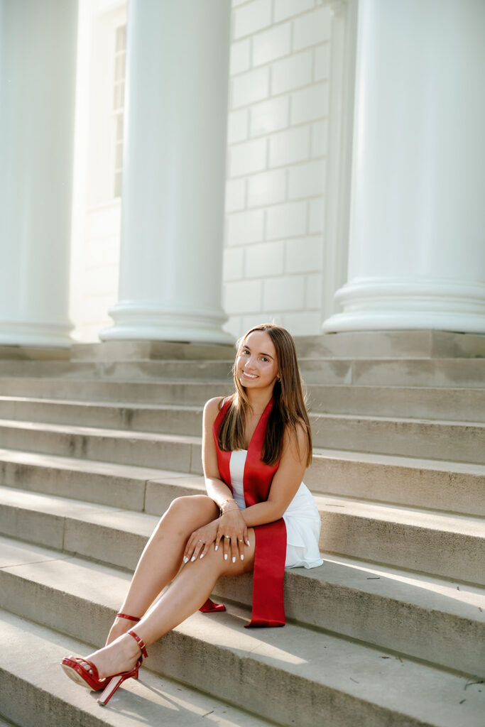 The University of Maryland Graduation photography of graduate sitting on the steps of the ESJ building