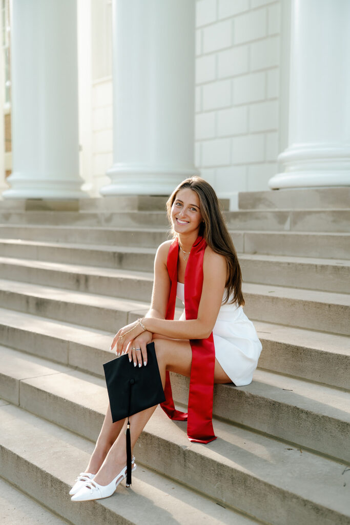 The University of Maryland Graduation photography of graduate sitting on the steps of the ESJ building