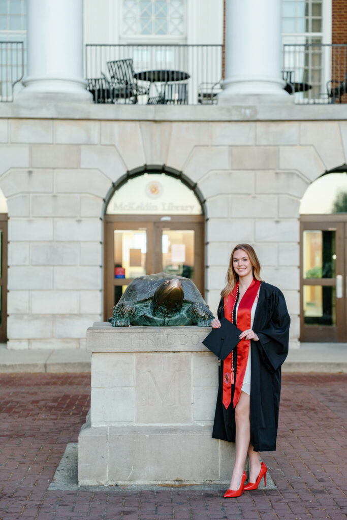Photo of graduate with Testudo Statue in front of McKeldin Library
